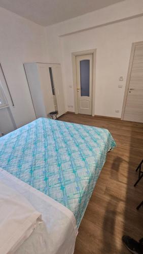 a bedroom with a bed with a blue comforter at La Venére 5Terre in La Spezia