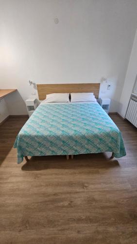a bed with a blue comforter in a bedroom at La Venére 5Terre in La Spezia