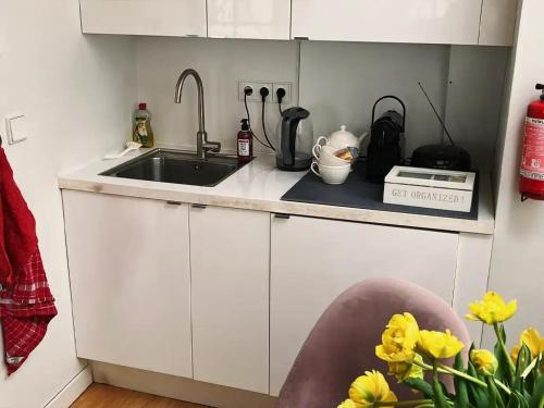 a kitchen with a sink and a counter with yellow flowers at Canal View B&B Amsterdam in Amsterdam