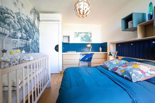 - une chambre bleue avec un lit bébé et un bureau dans l'établissement Appartement confortable à Marseille 100 m² avec vue, à Marseille