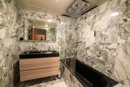 une salle de bain avec un lavabo et une baignoire dans l'établissement Appartement confortable à Marseille 100 m² avec vue, à Marseille