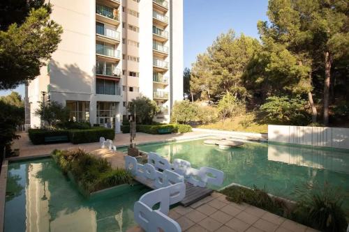 un hôtel avec une piscine devant un immeuble dans l'établissement Appartement confortable à Marseille 100 m² avec vue, à Marseille