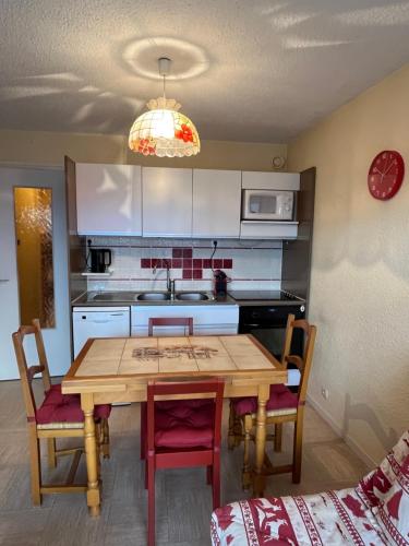 - une cuisine avec une table et des chaises en bois dans la chambre dans l'établissement Appartement 4-6 pers Plein sud, à L'Alpe-d'Huez