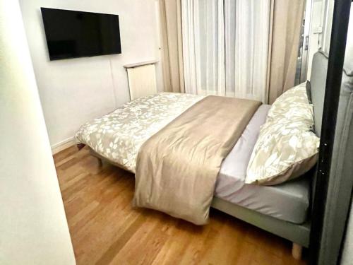 a bedroom with a bed and a television on a wall at Disney-Bord de Marne-Parking Privé in Meaux