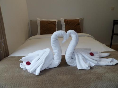 deux cygnes faits de serviettes sur un lit dans l'établissement World of Lovers *Paris*Disney*, à Bussy-Saint-Georges