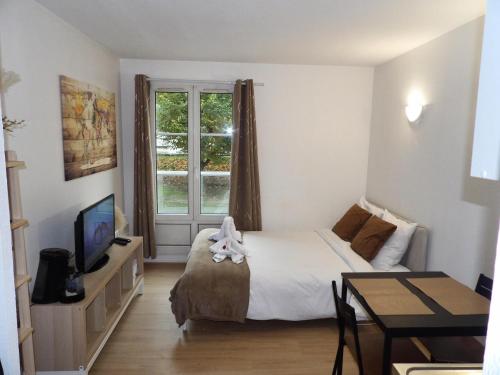 une chambre avec un lit, une table et une télévision dans l'établissement World of Lovers *Paris*Disney*, à Bussy-Saint-Georges