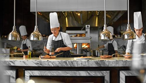 a group of chefs preparing food in a kitchen at Solaire Resort Entertainment City in Manila