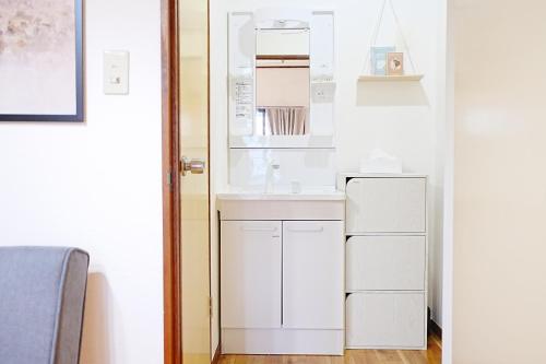a kitchen with white cabinets and a white refrigerator at Bohemian Tokyo in Tokyo