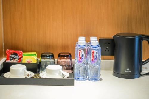 a counter with two bottles of water and a coffee maker at Kelly Jinyue Hotel in Chengdu