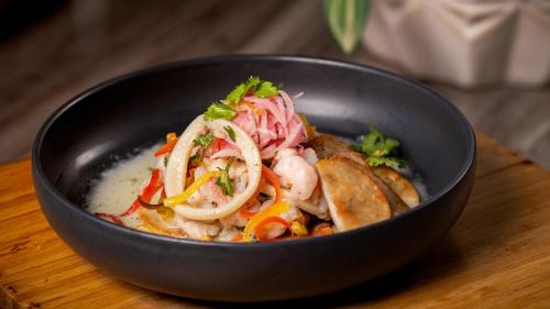 a black bowl of food on a wooden table at Holiday Inn Santo Domingo by IHG in Santo Domingo