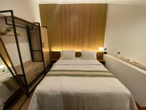 a bedroom with a large bed with white sheets at Muara Apartment Ubud in Ubud