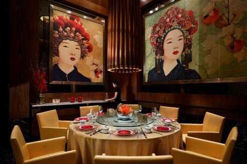a dining room with a table and chairs and paintings at Solaire Resort Entertainment City in Manila
