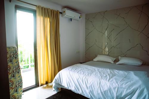 a bedroom with a bed and a large window at Arambol Bliss Hotel Apartments in Arambol