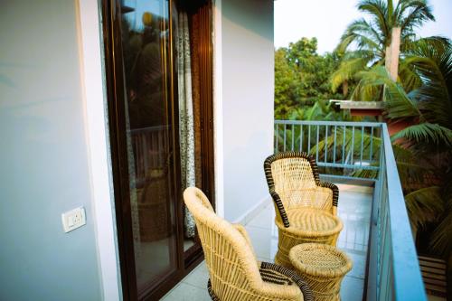 two wicker chairs sitting on a balcony at Arambol Bliss Hotel Apartments in Arambol
