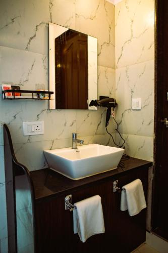 a bathroom with a sink and a mirror at Arambol Bliss Hotel Apartments in Arambol