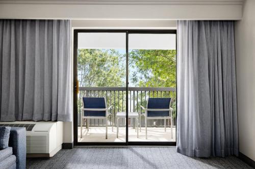 a room with a bed and two chairs on a balcony at Courtyard by Marriott Amarillo West/Medical Center in Amarillo