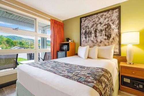 a hotel room with a bed and a window at Super 8 by Wyndham Lake George/Downtown in Lake George