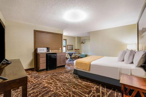 a hotel room with a bed and a kitchen at Super 8 by Wyndham Lake George/Downtown in Lake George