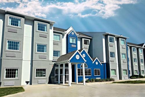 a large apartment building with blue and white at Microtel Inn & Suites by Wyndham Bluffs in Council Bluffs