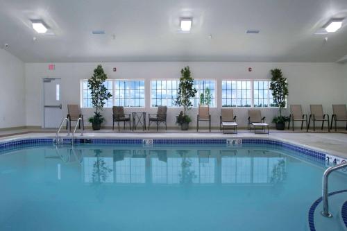 a pool in a hotel with chairs and tables at Microtel Inn & Suites by Wyndham Bluffs in Council Bluffs