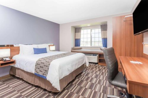 a hotel room with a bed and a desk at Microtel Inn & Suites Sault Ste. Marie in Sault Ste. Marie