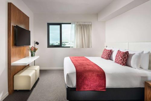 a hotel room with a large bed and a window at Ramada by Wyndham VetroBlu Scarborough Beach in Perth