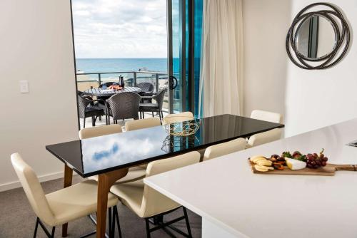 a dining room with a view of the ocean at Ramada by Wyndham VetroBlu Scarborough Beach in Perth