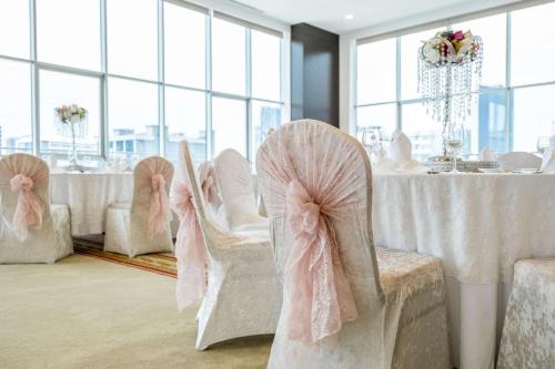 a dining room with white tables and chairs at Clarion Hotel Istanbul Mahmutbey in Istanbul