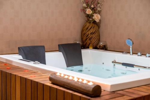 a jacuzzi tub with two chairs and a table at Clarion Hotel Istanbul Mahmutbey in Istanbul