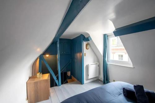 - une chambre avec des murs bleus et blancs et un escalier dans l'établissement Charmant appartement à Étretat, 30 m² avec cuisine équipée, à Étretat
