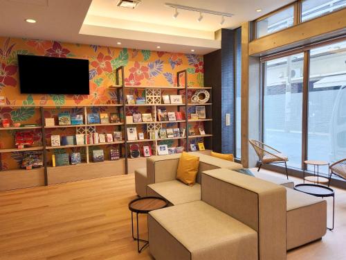 a living room with a couch and a tv on a wall at Comfort Hotel Naha Prefectural Office in Naha
