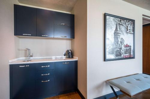 a kitchen with blue cabinets and a sink at Clarion Hotel Golden Horn in Istanbul