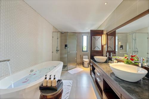 a large bathroom with two sinks and a tub at RiverTown Hoi An Resort & Spa in Hoi An