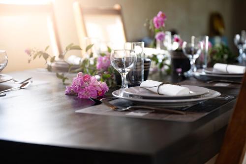 a table with plates and glasses and flowers on it at Le 53-LES MAKES in Saint-Louis