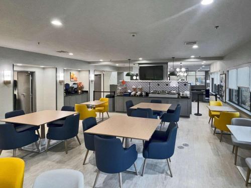 a restaurant with tables and chairs and a kitchen at Comfort Suites Mobile-South Alabama University Area in Mobile