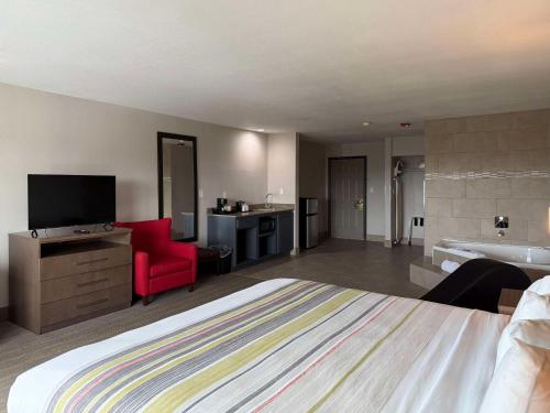 a hotel room with a large bed and a bathroom at Country Inn & Suites by Radisson, Harlingen, TX in Harlingen