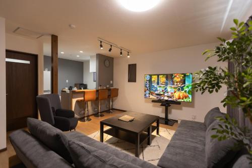 una sala de estar con un sofá y una mesa en ゲストハウス大垣心音, en Ōgaki