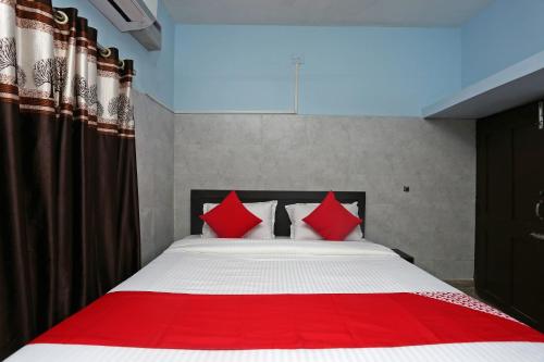 a bedroom with a large bed with red pillows at Hotel O The Ambience in Bhubaneshwar