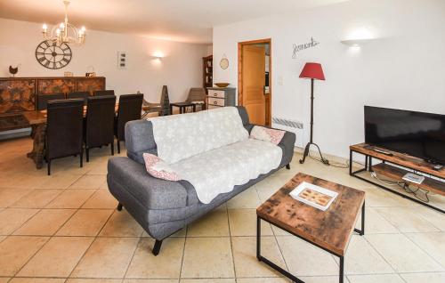 a living room with a couch and a tv and a table at Gorgeous Home In Saint Saturnin Lès Avi in Saint-Saturnin-les-Avignon