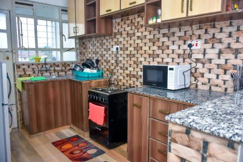 Home of comfort في ناكورو: مطبخ مع موقد وميكروويف