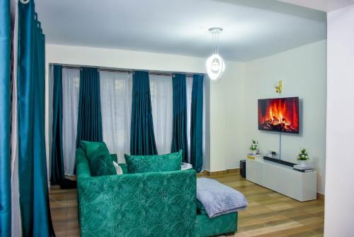 Home of comfort في ناكورو: غرفة معيشة مع أريكة خضراء وستائر زرقاء