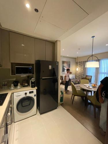 a kitchen with a washer and a refrigerator and a table at Dusit Thani Residence Executive Suite in Sasabayou