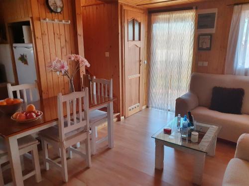 a living room with a table and a couch at Cabaña de madera especial y acogedora in Cardenete