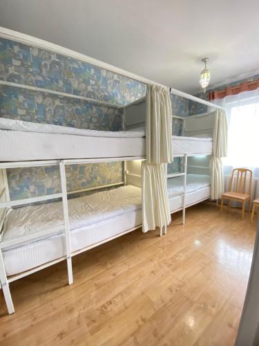 two bunk beds in a room with wooden floors at Хостел Особнячок in Bishkek