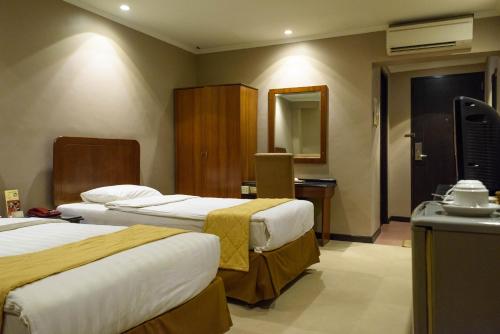 Posteľ alebo postele v izbe v ubytovaní Hotel Gajahmada Pontianak