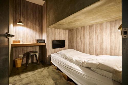a bedroom with a bed and a desk with a tv at York Hotel in Taipei