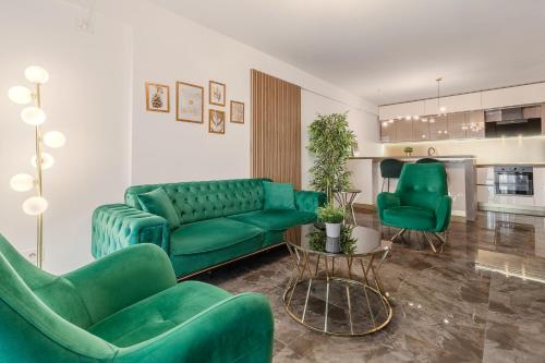 a living room with a green couch and two chairs at Sunset Flat in Oradea