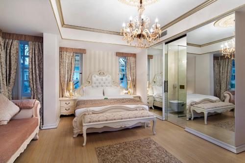 a large bedroom with two beds and a mirror at Elegance East Hotel in Antalya