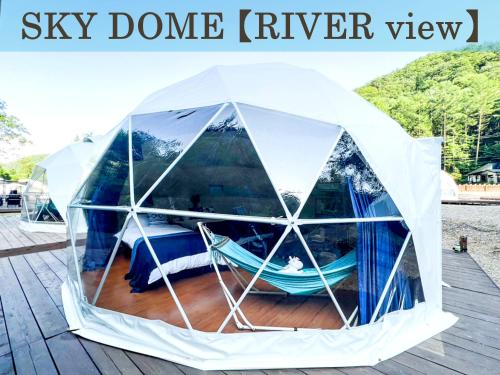 a tent with a hammock in it on a dock at Baco Resort Nagano in Ueda