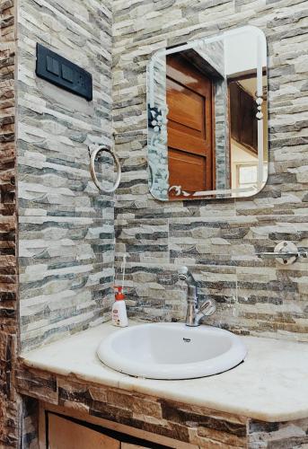 a bathroom with a sink and a mirror at Kiara Home stays in Varanasi
